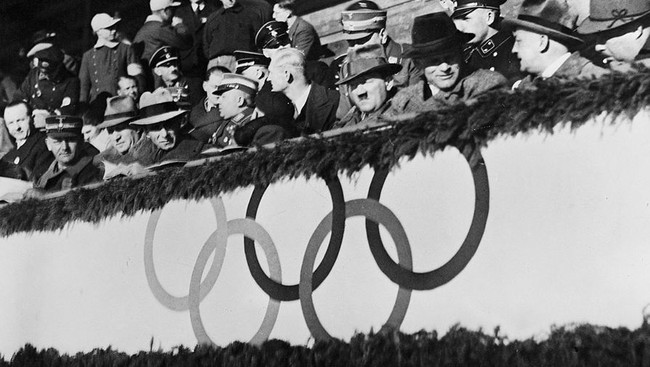 Олимпийские игры 1936, Гармиш-Партенкирхен. Явно скучающий Адольф Гитлер на хоккейном матче между командами Великобритании и Венгрии во время зимних Олимпийских игр 1936 г.